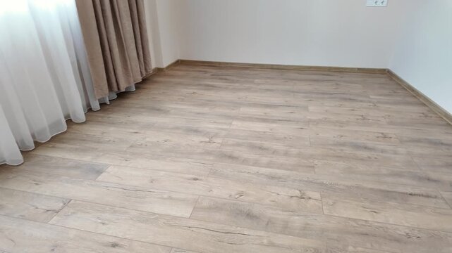 Natural wood laminate parquet floor. Room with laminate in new apartmen. Cozy home interior, modern design
