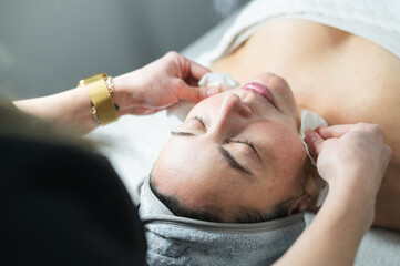 Woman receiving skin care facial treatment at spa