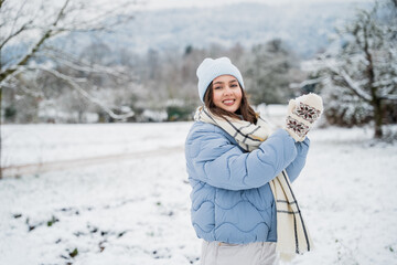 Winter holidays concept. Young happy woman playing with snow.