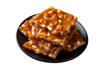 Peanut brittle toffee pieces on black plate for Lunar New Year snacks, isolated on transparent background