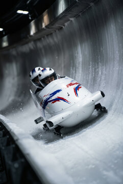 Bobsled team races down the icy track during a winter sports competition in a sliding center