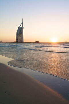Burj Al Arab at sunset with tranquil beach and sea in Dubai