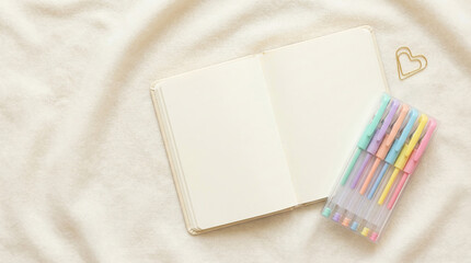 Valentines Day flatlay with a blank notebook and colorful pens on a soft background
