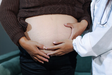 cropped shot of doctor examining pregnant woman during medical consultation