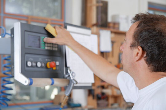 Carpenter operating control panel in carpentry workshop in Upper Bavaria