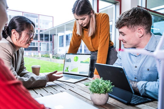 Teamwork meeting with digital devices and windmill model in modern office