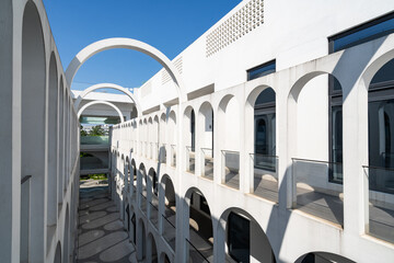 Naklejka premium White arched architectural corridor under blue sky