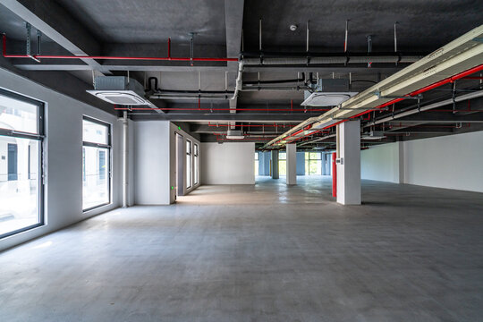Empty commercial space with exposed ceiling pipes
