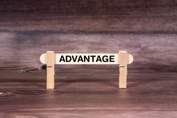 Fototapeta premium Advantage symbol. Clothespins gripping a wooden stick against a beautiful Brown Wooden Background . Business and Advantage concept with copy space