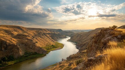 Naklejka premium Scenic view of winding river flowing through dry canyon landscape at sunset. Nature background for travel and environmental concept.
