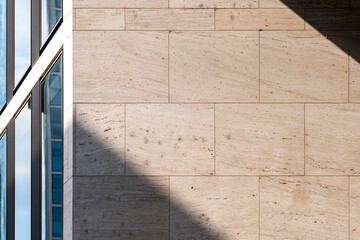 Minimal stone wall texture with shadow and sunlight contrast in architecture creating abstract background for modern design with copy space