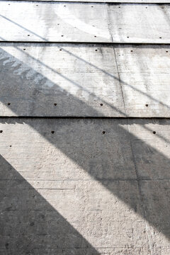 Concrete surface texture with lines and shadow pattern in sunlight creating minimal abstract background for modern architecture design and copy space
