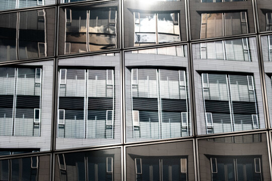 Office windows facade grid with urban glass reflection and modern architecture pattern in daylight creating clean futuristic business background
