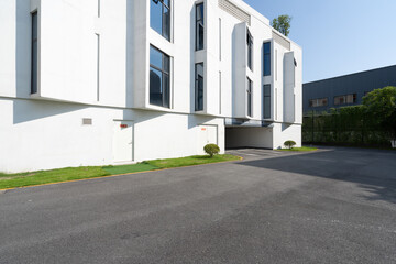 Minimalist white geometric architecture with asphalt road