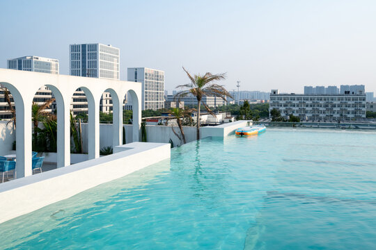 Infinity pool overlooks sunny urban skyline
