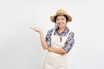 young Asian farmer is making an open palm gesture. She smiles and looks happily at the camera. There is space for advertising products, isolated on a white background.