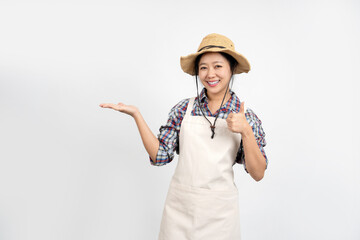 Portrait of young Asian female farmer in apron and pointing hand aside isolated on background. Small business startup concept