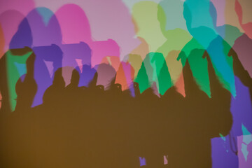 Colorful shadows cast on a wall through RGB lighting