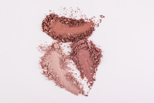 Three chic swatches of matte eye shadows in brown shades on a white background. glosses, shine of pearlescent makeup, decorative cosmetics. top view.