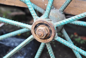 Rusty Metal Wheel Hub with Turquoise Spokes Close-Up