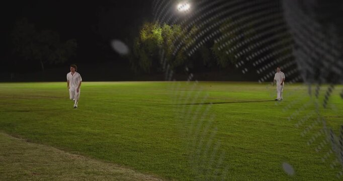 Fielder seeing ball rising getting ball under cricket lights while dotted overlay obscuring fielder