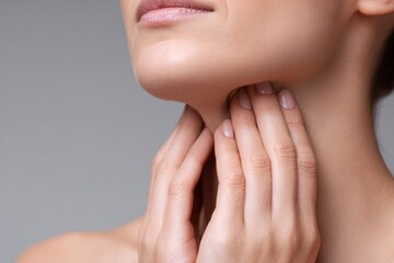 Woman with a sore throat touching her neck. Female checking thyroid gland or swollen lymph nodes. Healthcare and medical concept