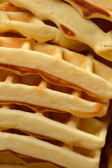 Macro shot showing the side profile and detailed square patterns of a high stack of freshly baked...