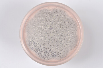 A top view of a round transparent plastic lid covered with many small condensation water droplets...