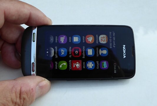Hand holding Nokia Asha 311 touchscreen mobile phone