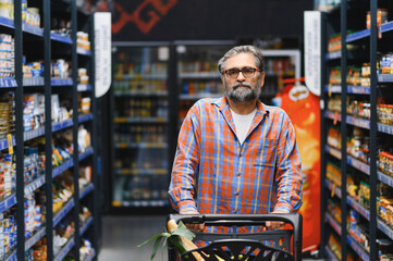 Fototapeta premium Senior man at grocery store products