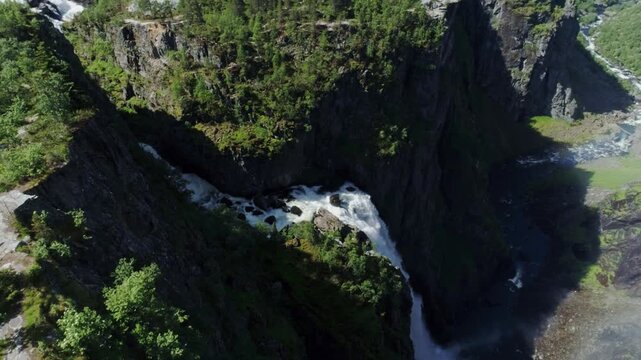 Cinematic drone flight moves closer toward V&oslash;ringsfossen as camera tilts down