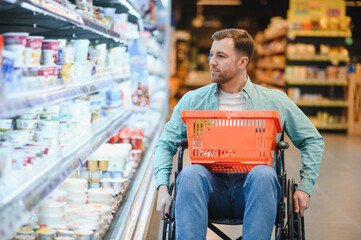 Customer in wheelchair choosing groceries in supermarket