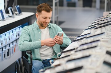 Customer in wheelchair using smartphone in electronics store