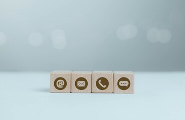 Customer contact and business communication concept with wooden blocks displaying email, phone,...