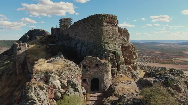 Closer ascending drone view of the entrance of Pe&ntilde;a Negra Castle in Mora, Toledo, revealing its small pedestrian scale, not designed for carts, and the stone details of the medieval fortress.