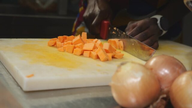 Close view of concass&eacute; cut yam, Dioscorea rotundata, gently saut&eacute;ing in fat inside a metal pot as a technical base for velout&eacute;, showing controlled cooking process, texture change, starch release