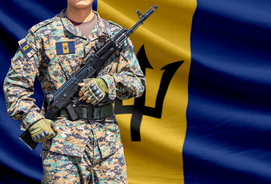Barbados flag with soldier in military uniform holding assault rifle in front of it
