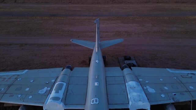 Aerial view of a weathered airplane with peeling paint standing on a desolate brown landscape under a dusky sky, Tucson, Arizona, United States.