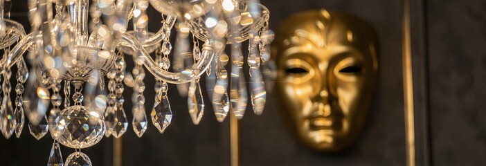 Crystal chandelier with gold mask in luxurious interior setting