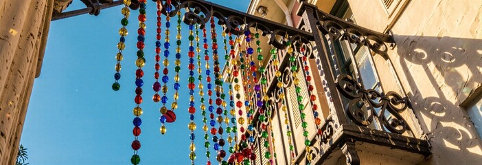 Colorful beads and elegant ironwork on historic balcony