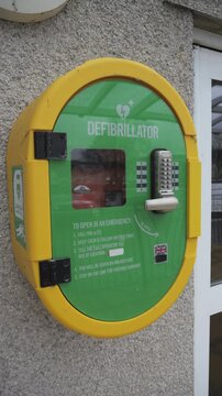4K: A Defibrillator AED hanging outside a building on the wall for First Aid Medical help. Vertical. Stock Video Clip Footage.