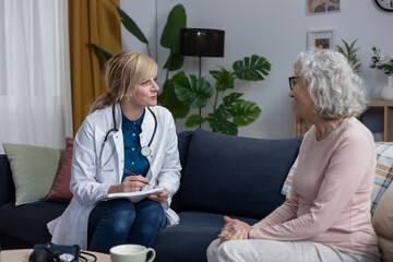 Obraz premium Doctor providing home healthcare visit for senior woman