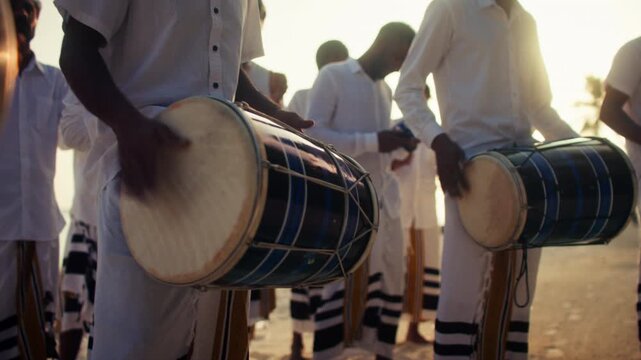 Traditional Bodu Beru drummers perform on tropical beach at sunset