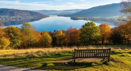 Obraz premium Scenic Lake View in Autumn with Wooden Bench Overlooking Serene Waters and Colorful Foliage