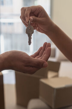 Hands exchanging home keys representing new ownership moving