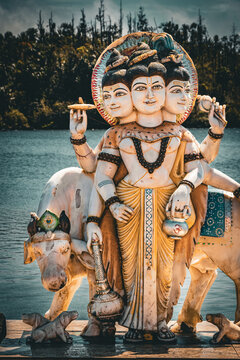 Beautiful view of a statue of the Hindu deity Dattatreya Trimurti (the Divine Trinity) on the shore of the Ganga Talao, Grand Bassin, Mauritius