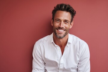 Obraz premium grinning man in his 40s wearing a classic white shirt in solid color backdrop
