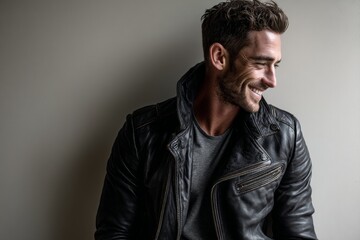 Fototapeta premium smiling man in his 30s sporting a classic leather jacket over light wood minimalistic setup