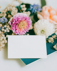 Elegant wedding card mockup surrounded by soft blooms in a serene setting, perfect for showcasing unique designs and personal touches for special celebrations