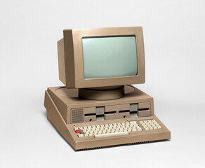 Old beige personal computer representing vintage computing technology on a white background